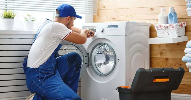 Technician checking front-loading laundry appliance controls