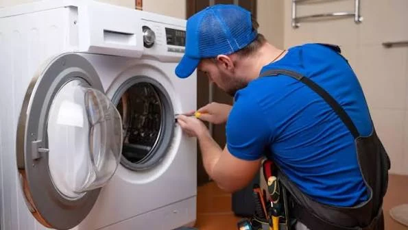 Technician inspecting the door seal of a front-loading washing machine